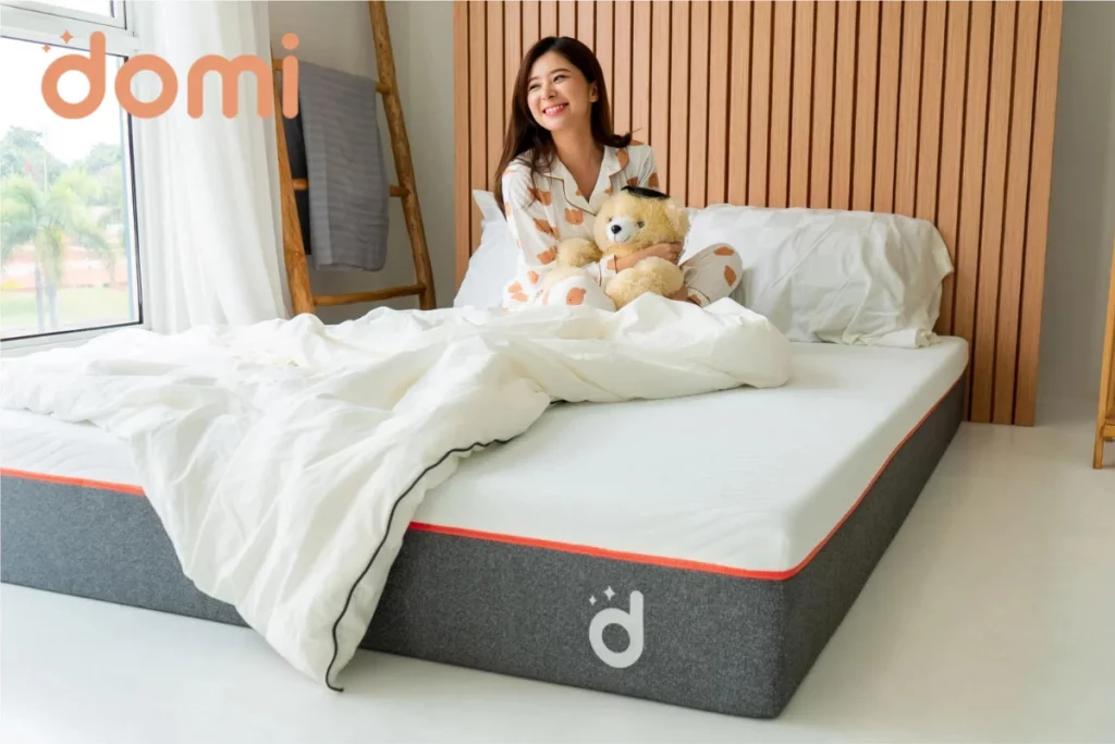 Orang yang sedang duduk di atas kasur Air Mattress Domi