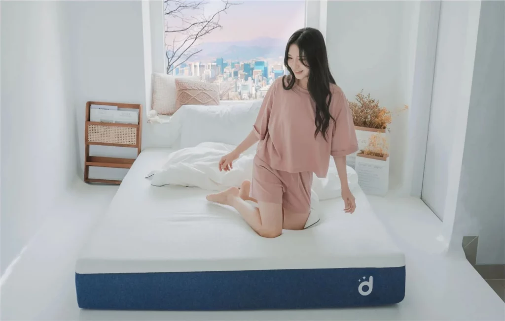 Perempuan duduk di atas Domi Cloud Mattress